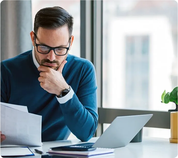Professional man working at desk with papers and laptop